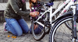 Eine Mutter repariert mit ihrer Tochter den Hinterreifen eines Fahrrads